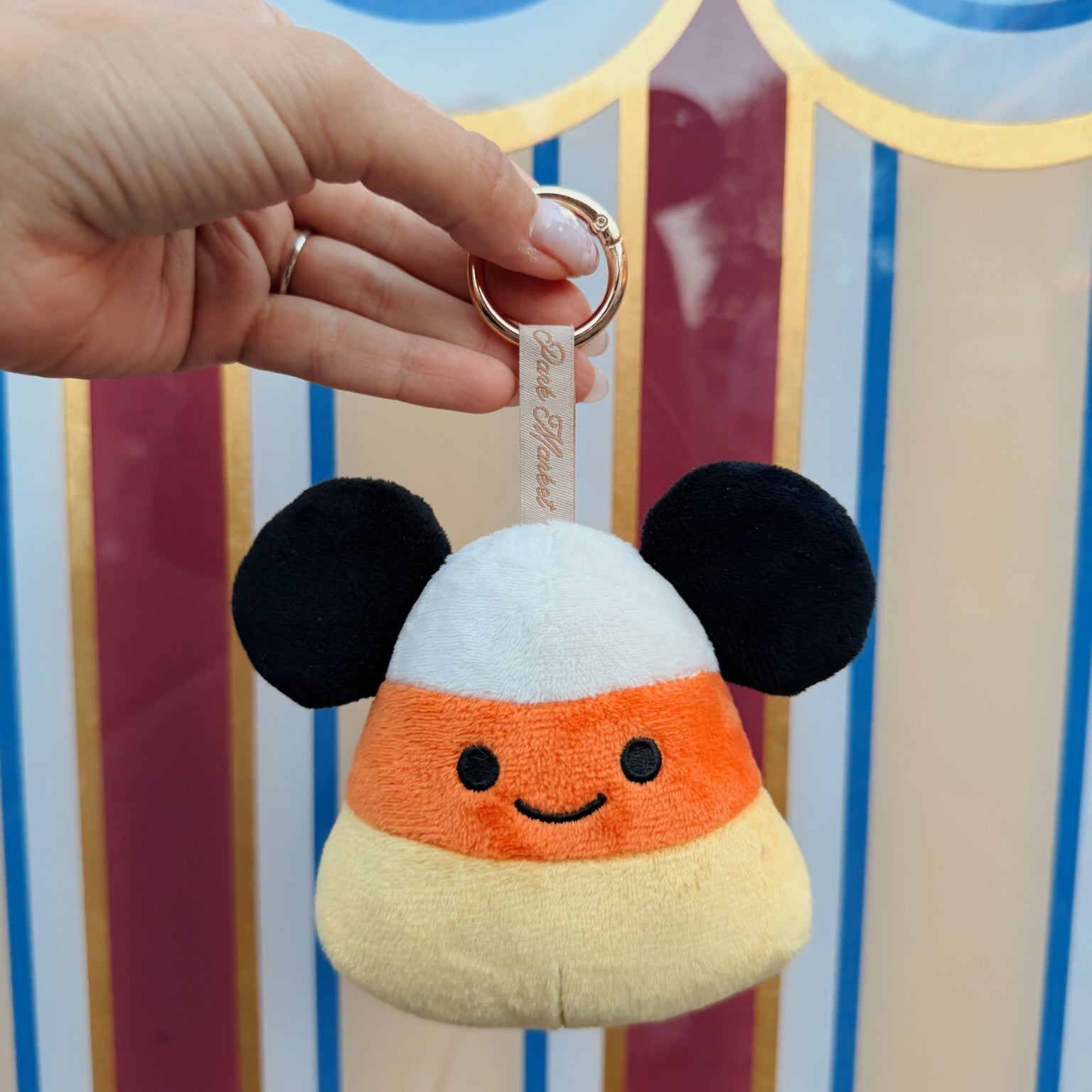 Candy corn plush bag charm held in hand