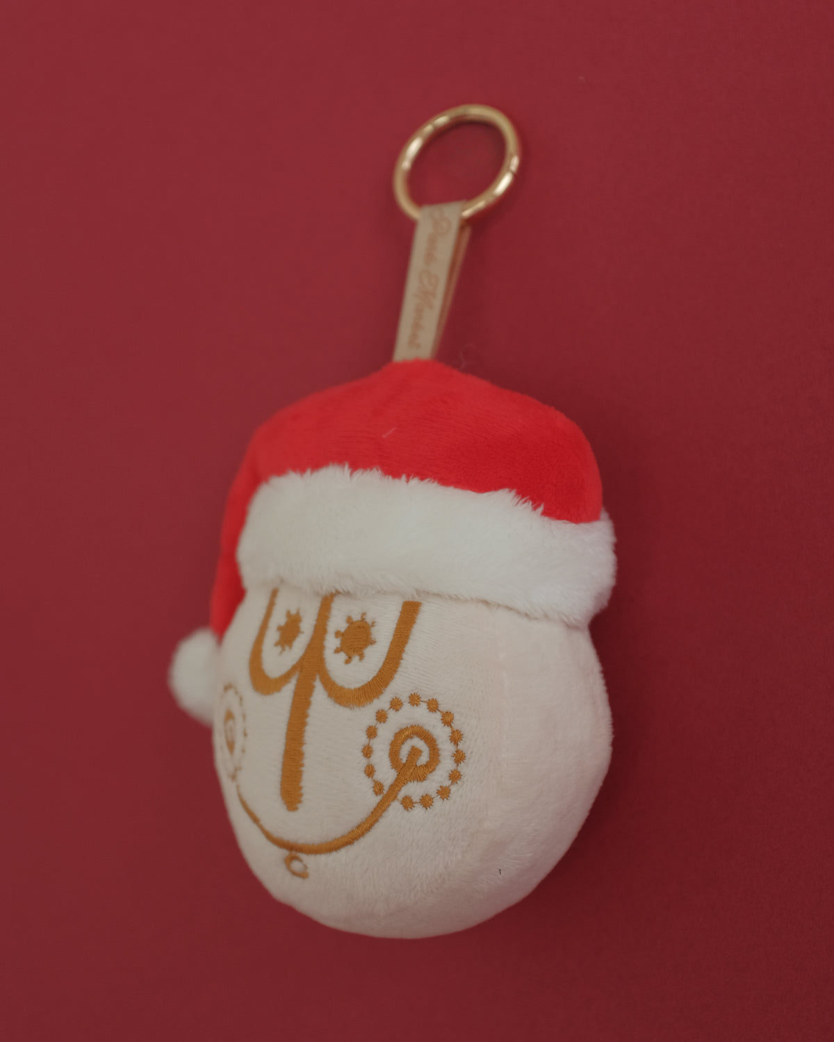 Tinsel Time bag charm at an angle, showing the embroidered clock face and Santa hat