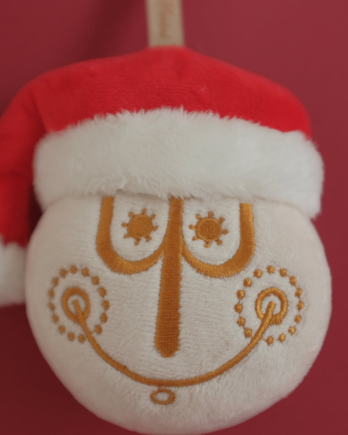 Close-up of Tinsel Time's gold embroidered clock face and fur-trimmed Santa hat