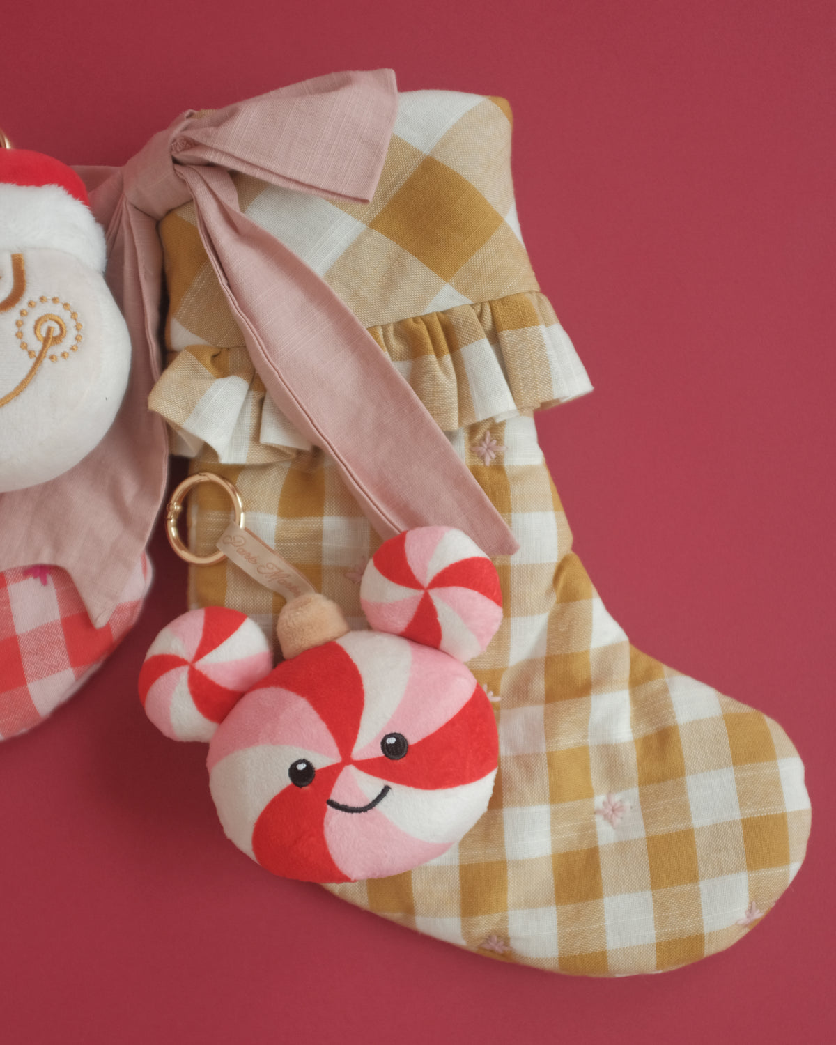 Peppermint Pal bag charm tucked into a gingham Christmas stocking with a ribbon