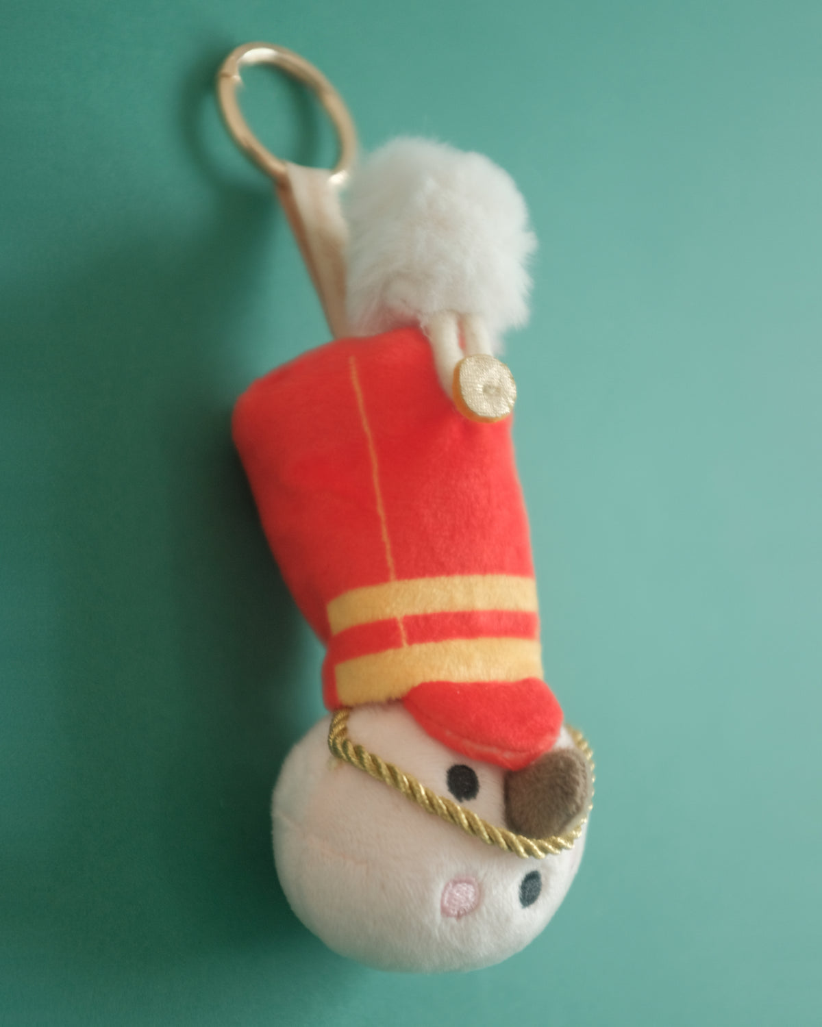 Close-up of The Merry Marcher's embroidered face, rosy cheeks and gold hat rope