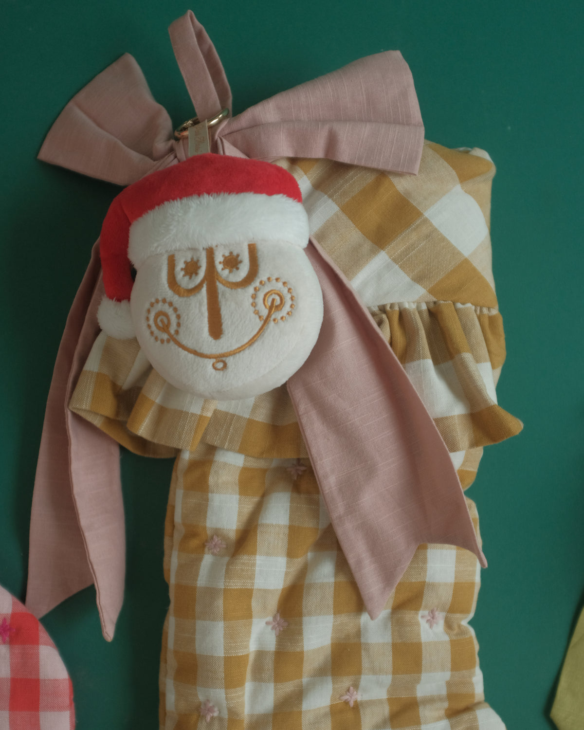 Tinsel Time bag charm hanging from a ribbon on a gingham Christmas stocking