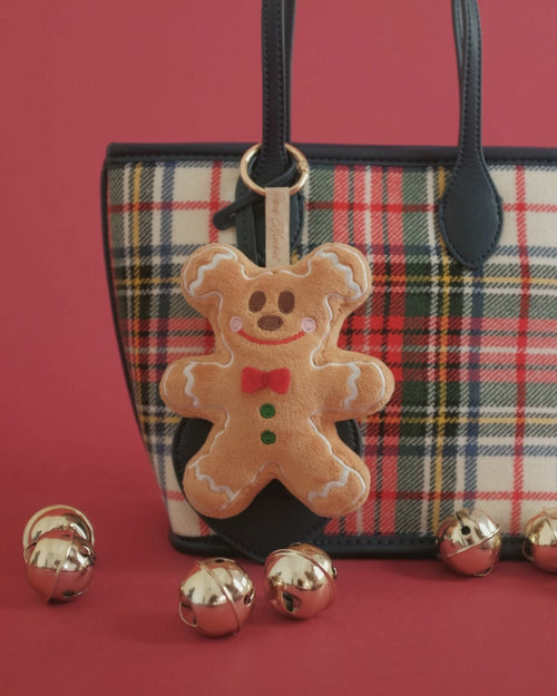 Gingerbread Gent bag charm on set: clipped to a plaid tote, an embroidery close-up, gold bells and falling snow
